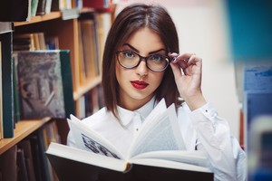 Девушка в очках читает книгу